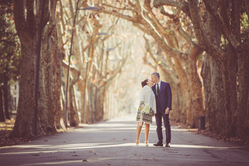 bacio tra sposi in un viale alberato
