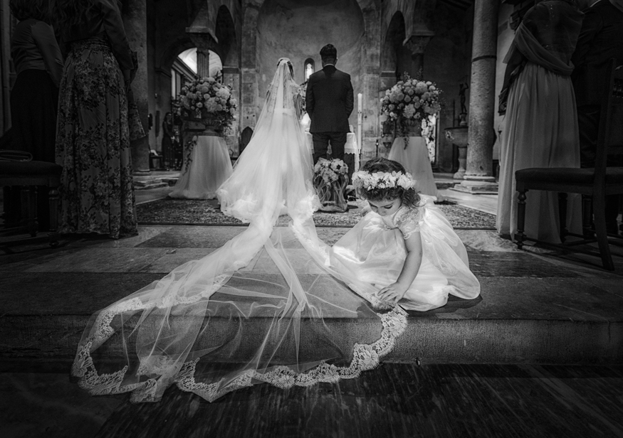 damigella stende il velo della sposa lungo al navata